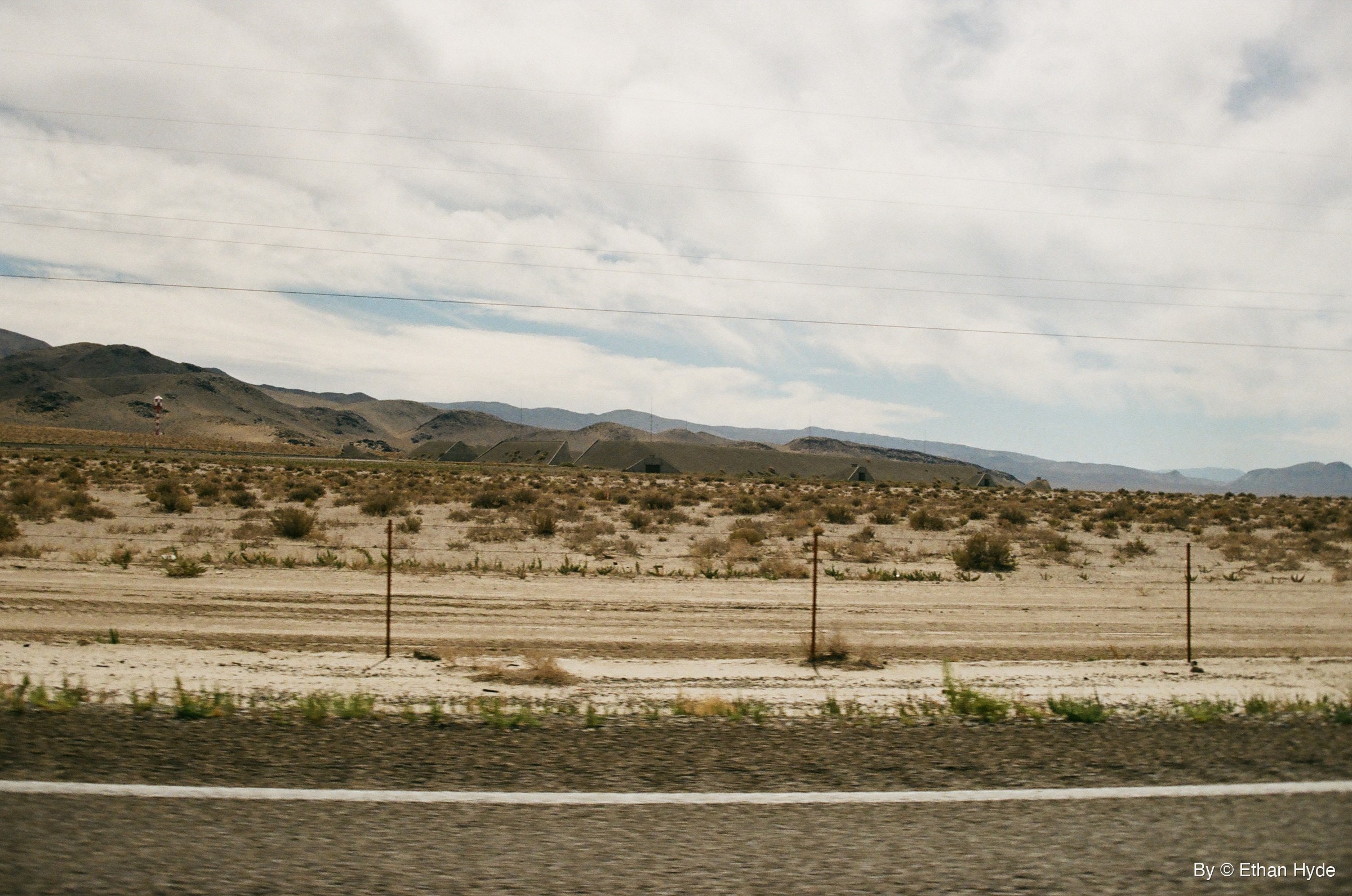 Earth-covered ammunition bunkers spread across a desert valley near Hawthorne, Nevada, shot on film.