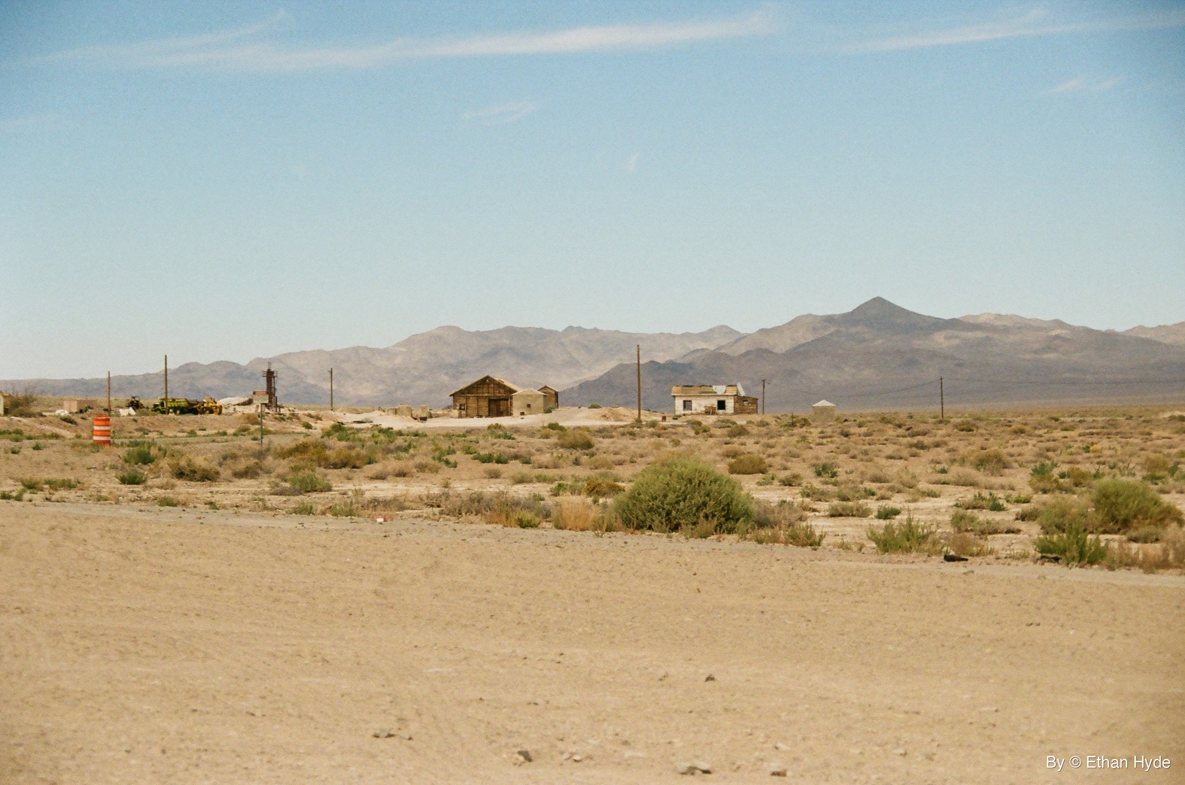 Small buildings scattered across open desert beneath bare mountains in Luning, Nevada, shot on film.