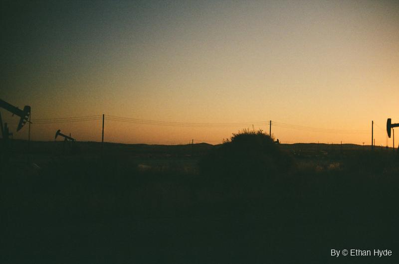 Pumpjacks silhouetted against an orange dawn sky over the oil fields near McKittrick, California, shot on film.