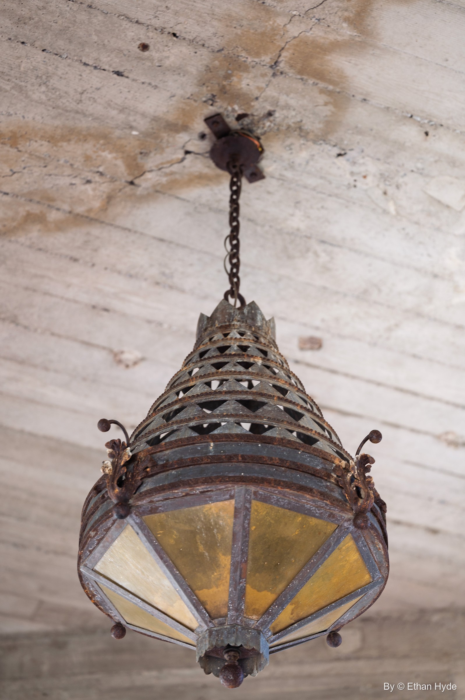 A hand-wrought iron and amber-glass lantern hangs from a chain inside Scotty's Castle, part of the ironwork designed for each room.