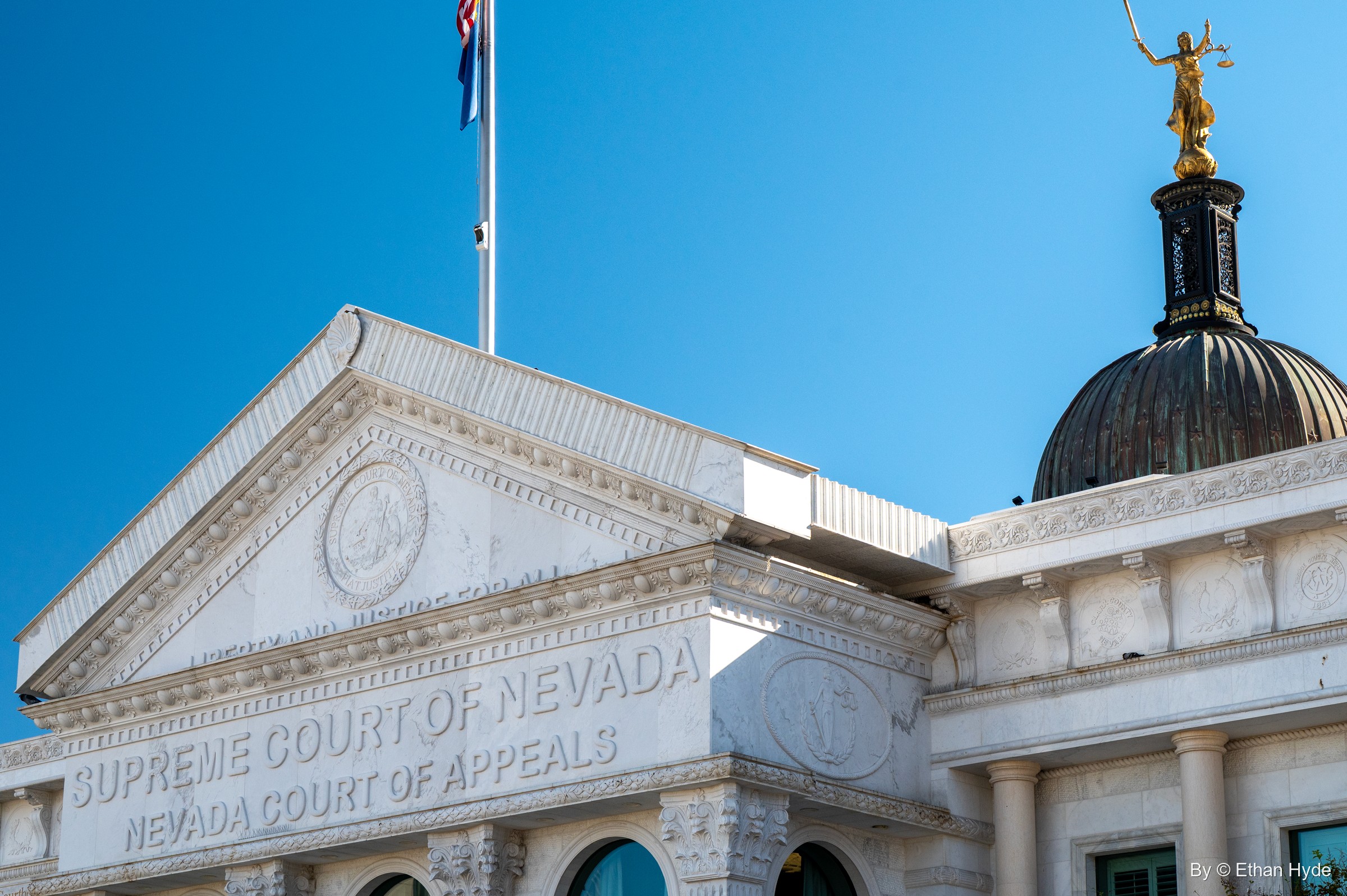 A white pediment lettered "Supreme Court of Nevada, Nevada Court of Appeals" below a dome topped by Lady Justice.