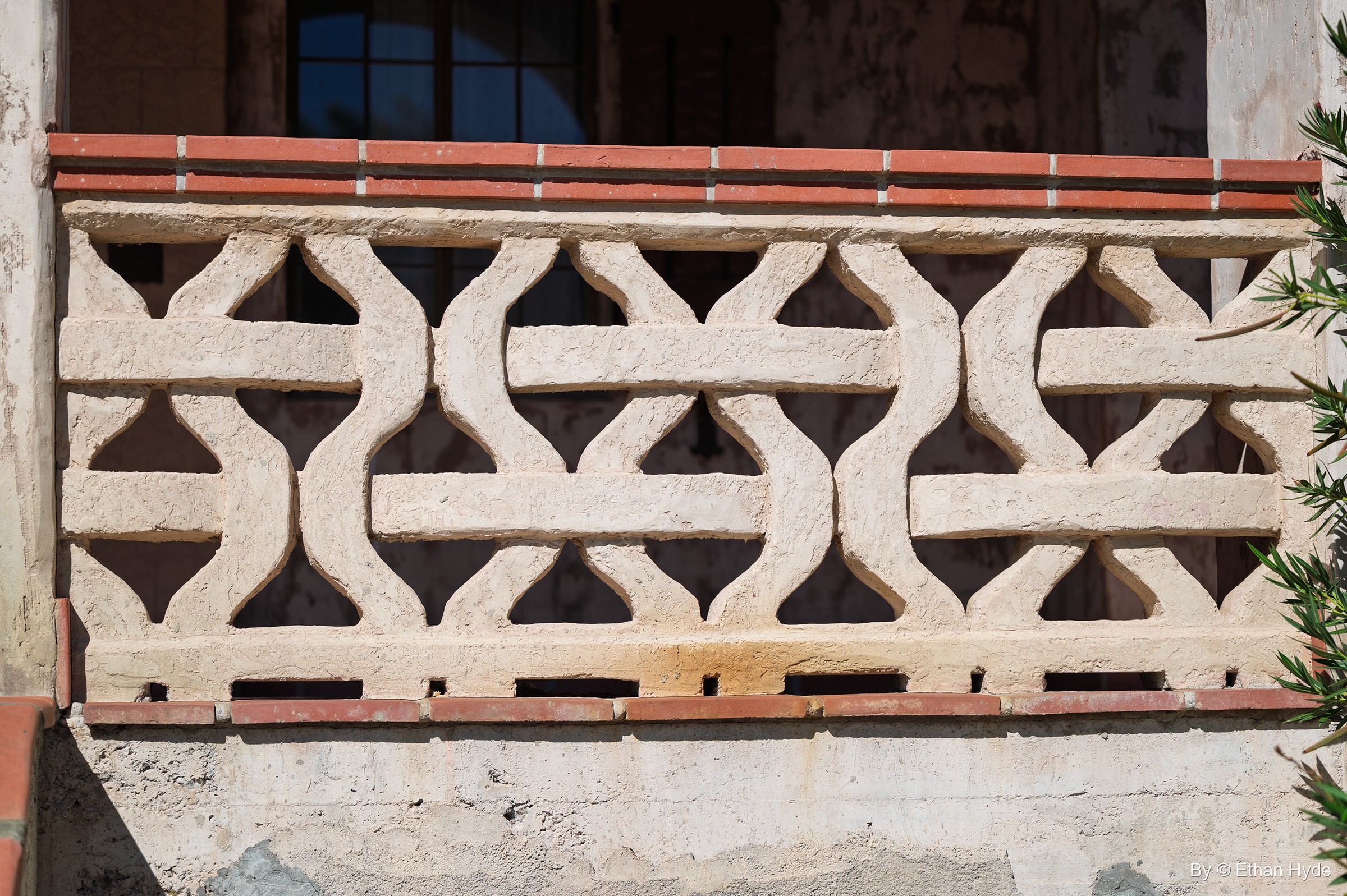 A pierced stucco balustrade with an interlocking wave pattern and red tile coping at Scotty's Castle.