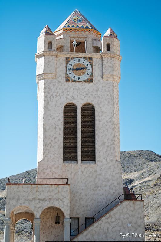 The Chimes Tower at Scotty's Castle with its clock, louvered openings and an exterior stair climbing the arcaded base.