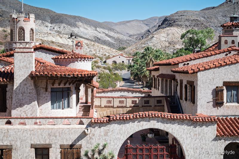Looking over the red tile rooftops of Scotty's Castle toward palms and the mouth of Grapevine Canyon.