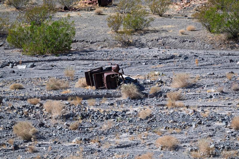 A single overturned, rusted vehicle body in a gravel wash near Scotty's Castle.