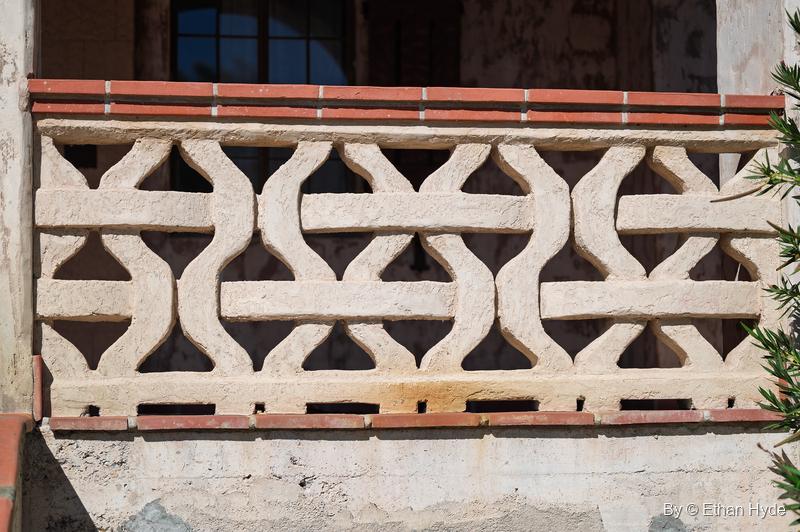 A pierced stucco balustrade with an interlocking wave pattern and red tile coping at Scotty's Castle.