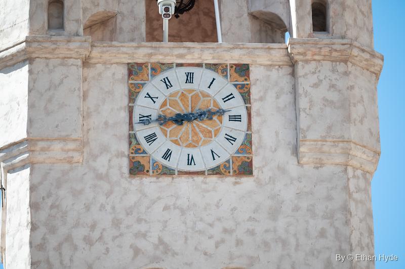 A Roman-numeral clock face set in patterned tile on the stucco wall of the Chimes Tower at Scotty's Castle.